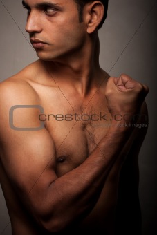 Portrait of young Indian angry man over dark background