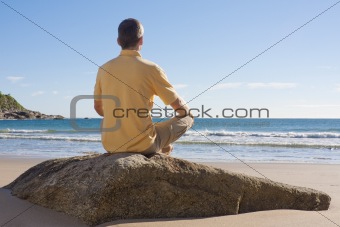 Man meditating on a beach