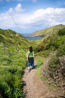 woman hiking towards sea
