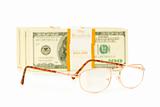 Glasses and dollar stack isolated on white