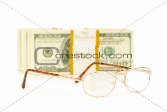 Glasses and dollar stack isolated on white
