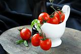 cherry tomatoes and basil in a white gravy boat