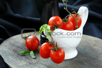 cherry tomatoes and basil in a white gravy boat