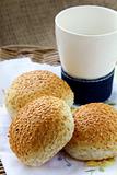 fresh rolls with sesame seeds and a glass of milk