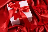 Red ribbon holiday gift on satin 