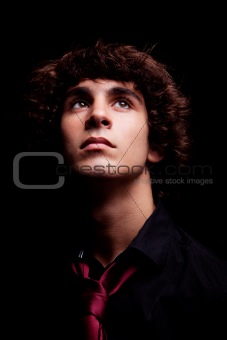 young man looking up , isolated on black, studio shot