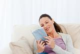 Lovely woman reading a romance sitting on the sofa