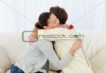 Lovely woman hugging his boyfriend after receiving a flower
