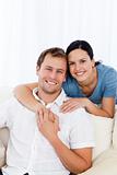 Passionate woman hugging her boyfriend while relaxing on the sofa