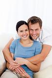 Portrait of a happy man hugging his girlfriend while relaxing 
