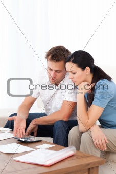 Desperate couple doing their account sitting on the sofa 