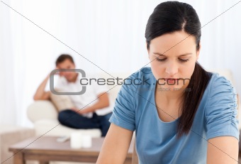 Woman thinking at a table while her boyfriend waiting