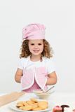 Cute girl with kitchen gloves while preparing cookies