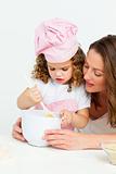 Cute girl  preparing a cake with her mother