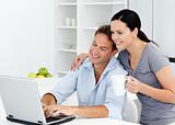 Affectionate woman looking at her boyfriend working on the laptop