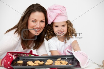 Lovely mother and daughter holding a plate with biscuits