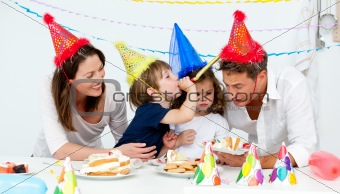 Happy family having fn while eating birthday cake