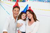 Portrait of cute little girl with her parents during a birthday