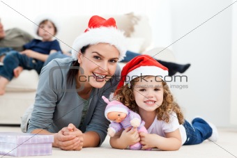 Happy mother and daugher at christmas lying on the floor 