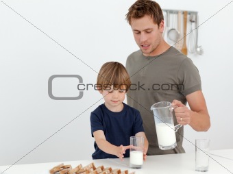 Handsome man giving milk to his son