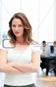 Proud businesswoman standing in front of her team while working