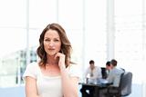 Pensive businesswoman standing in front of her team while working