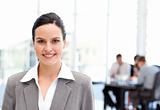 Adorable businesswoman standing in front of her team while working