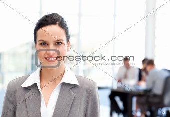 Adorable businesswoman standing in front of her team while working
