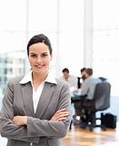 Cheerful businesswoman standing in front of her team while working