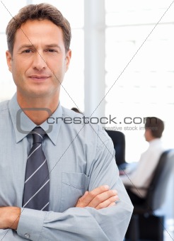 Assertive businessman standing in front of his team while working