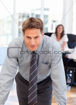 Confident man posing in front of his colleague during a meeting
