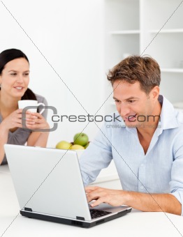 Couple looking at something on internet while drinking coffee
