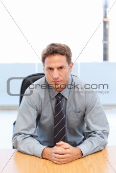 Confident manager posing alone at a table