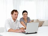 Happy man and woman looking at something on the laptop