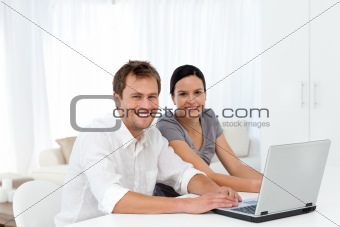 Portrait of a couple working on their laptop in the living room 