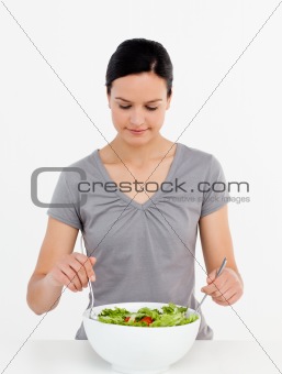 Lovely woman mixing a salad standing in the kitchen 