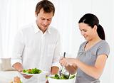 Happy woman serving salad to his boyfriend for the lunch