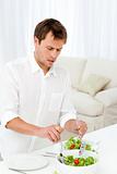Single man serving salad standing at a table