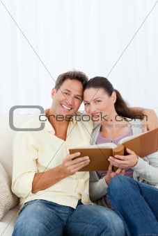 Portrait of a happy couple looking a photo album