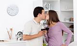 Cute couple kissing with glasses of red wine in their hands