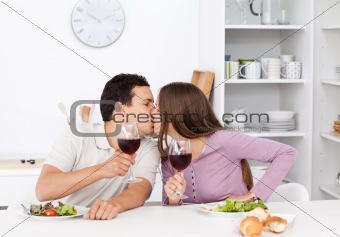 Lovely couple giving a toast while eating a salad