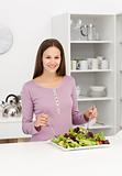Cute woman mixing a salad standing in the kitchen