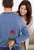 Impatiente woman looking at a flower hidden by her boyfriend