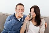 Relaxed couple drinking champagne on the sofa