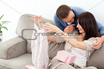 Passionate man giving a top to his girlfriend while relaxing 