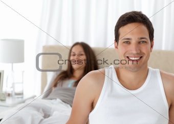Handsome man on the edge of the bed with his girlfriend