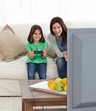 Pretty mom encouraging her daughter playing video games 