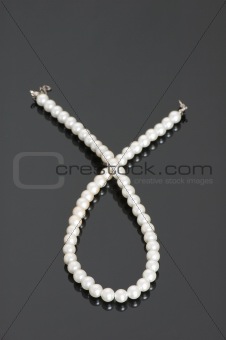 Pearl necklace on the shiny reflective background