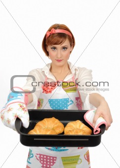 Beautiful cooking woman in apron eating  croissant bread