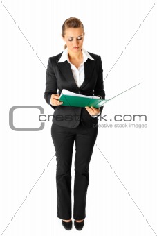 Full length portrait of serious modern business woman exploring documents
